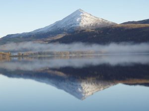 The summit of Mount Schiehallion with a msity ground covering making a mystical scene.