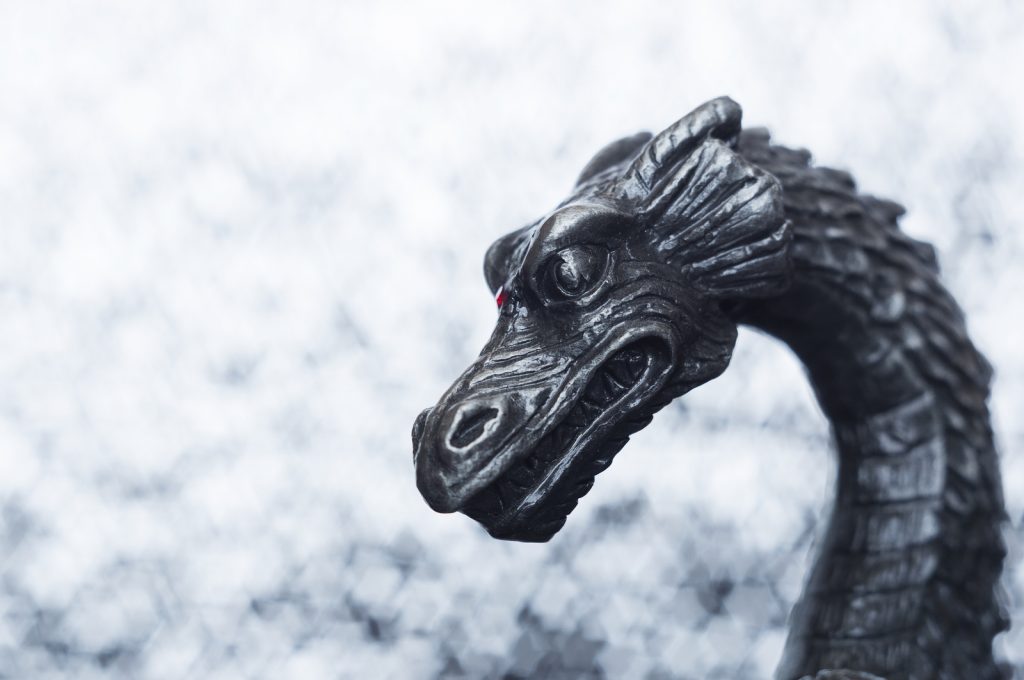 An old antique metallic dragon's head close-up.