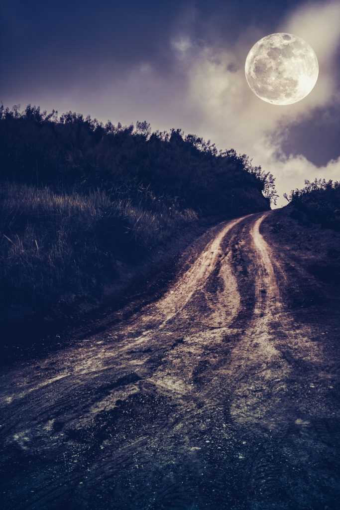 Landscape in nature of beautiful full moon a muddy road through a forest. Mountain winding road passing outdoors at nighttime. Dark tone. Vintage effect tone. 