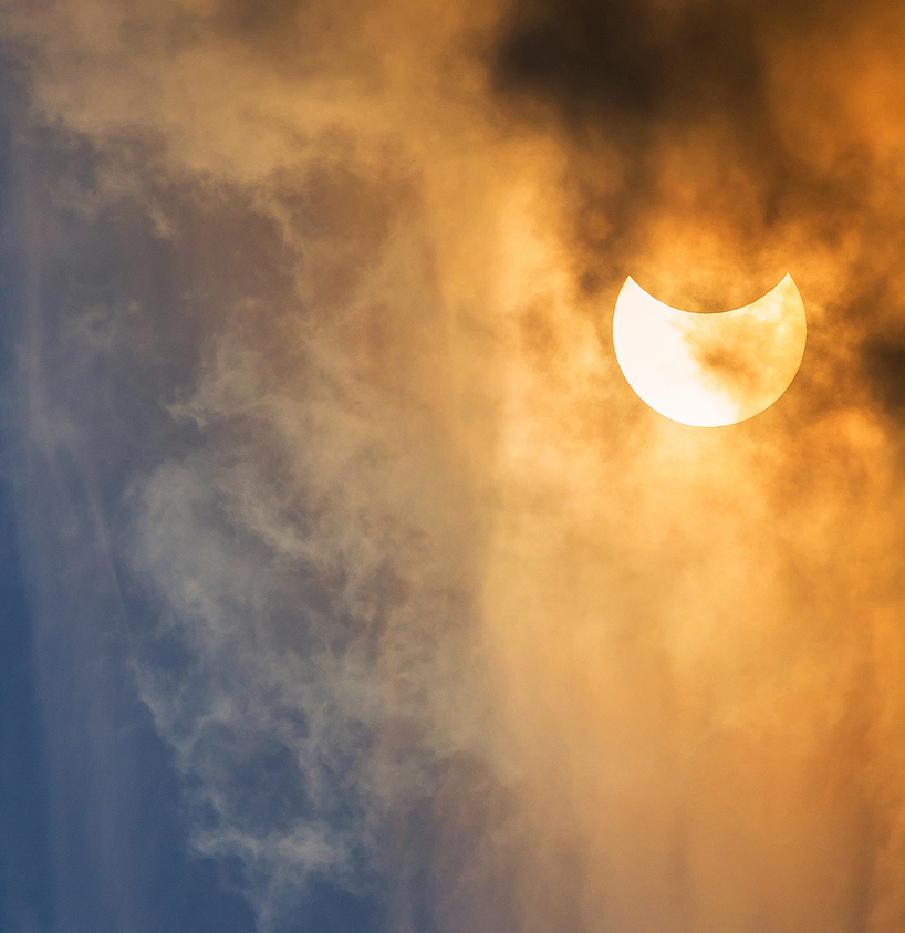 The Moon covering the Sun in a partial eclipse with dramatic cloud. Scientific background astronomical phenomenon