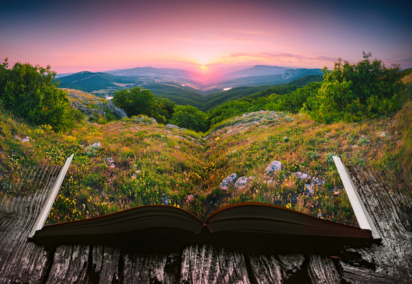 Sunset in a mountain valley on the pages of an open magical book. 