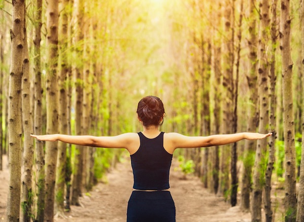 Woman with open arms in balance in nature