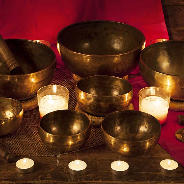 singing bowls and bells with burning candles