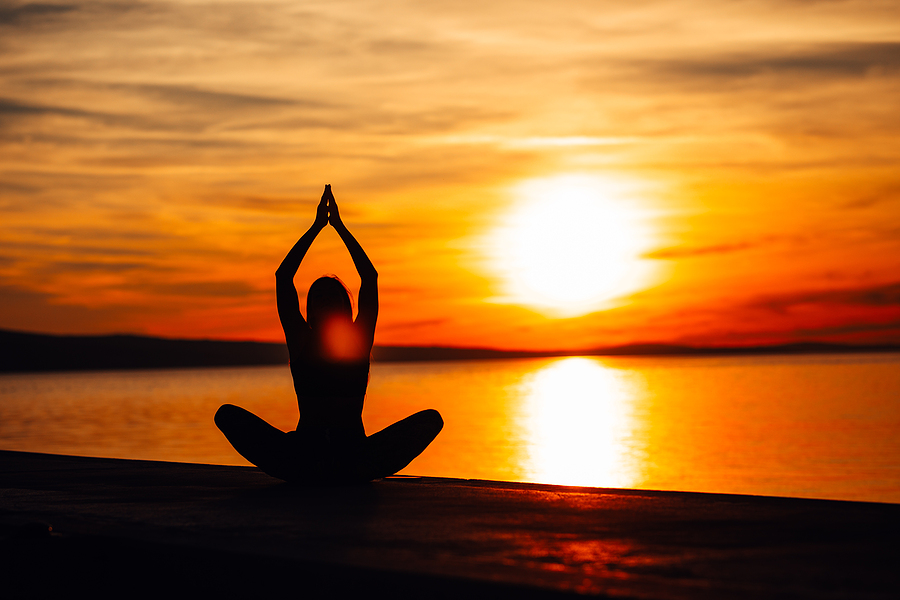 Carefree woman meditating in nature.Finding inner peace.Yoga practice.Spiritual healing lifestyle.Enjoying peace,anti-stress therapy,mindfulness meditation.Positive energy.Upward salute back bend pose